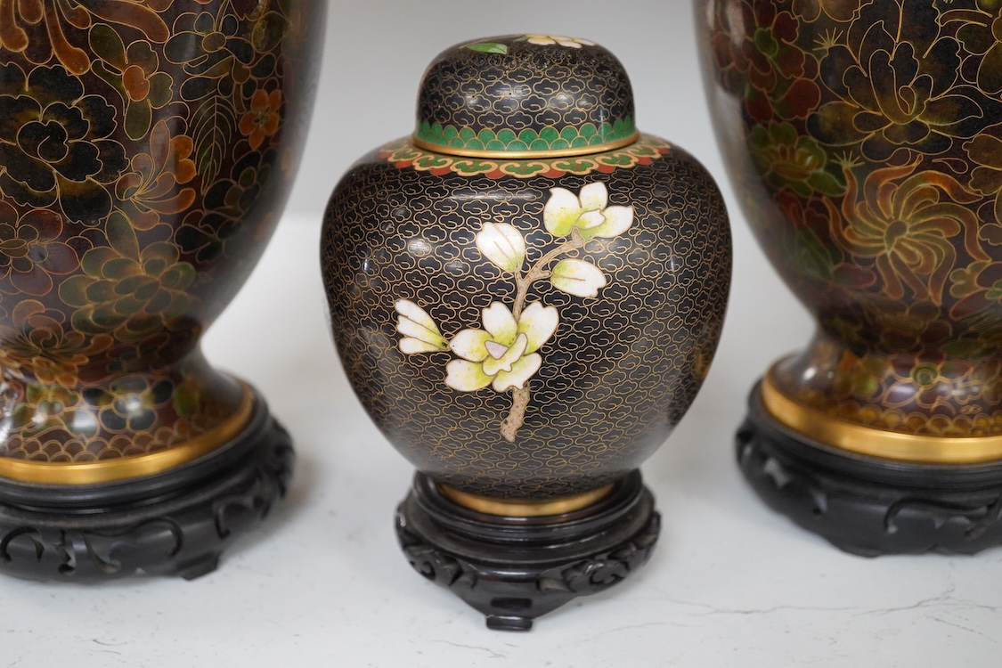 A pair of Chinese cloisonné enamel vases on stands and similar ginger jar, vases 34.6cm high including stands.